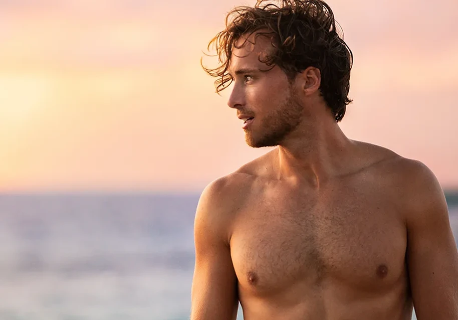 Confident young man standing by the sea.