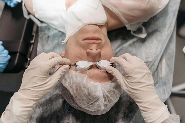 A cosmetic surgeon in London preparing for a precision facial procedure on a patient in a clinical setting.