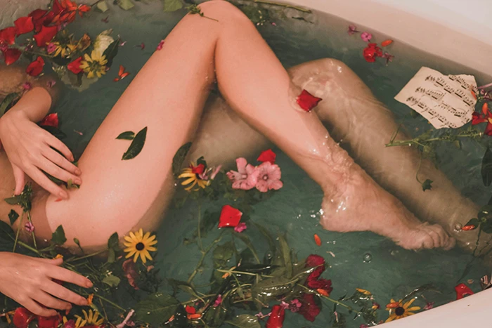 a woman in a bathtub full of flowers