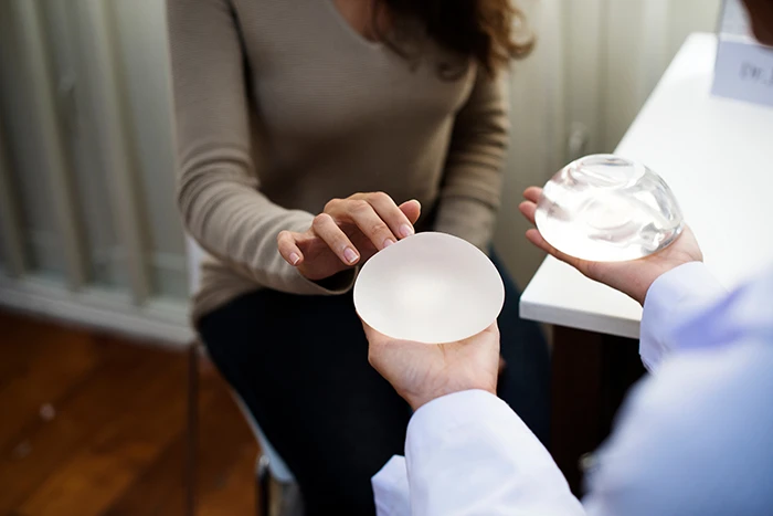 woman holding breast implants