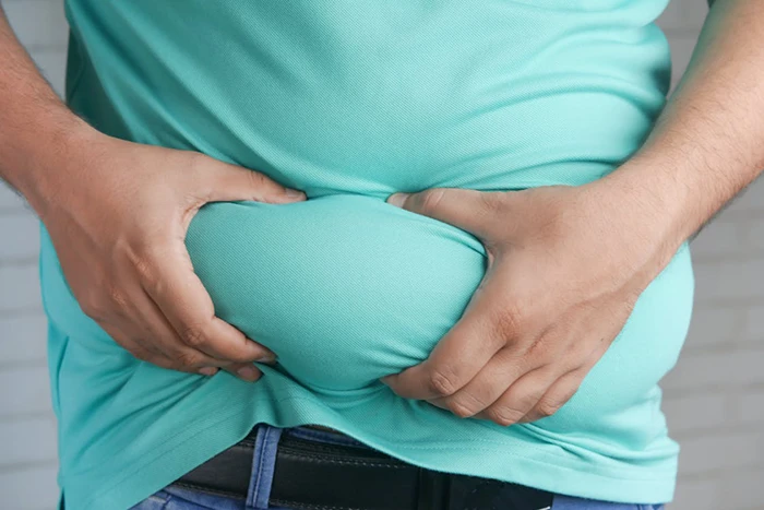 A picture of a man holding excess abdominal fat with both hands