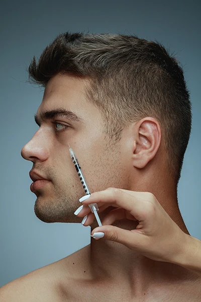 A young man receiving a Botox injection near his eye to reduce wrinkles