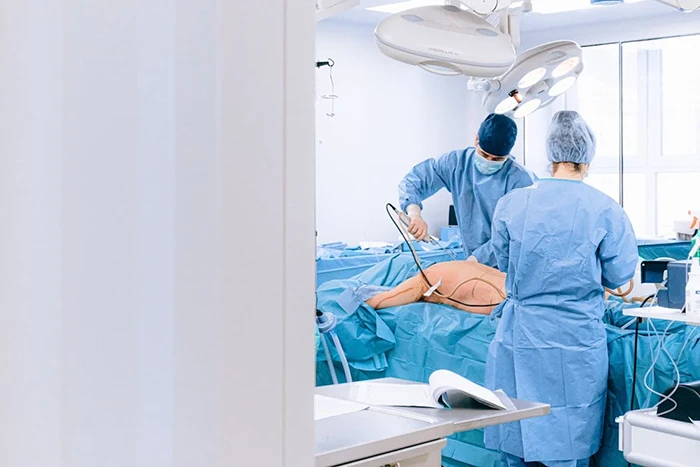 A picture of surgeons performing thigh lift surgery in a sterile operating room.