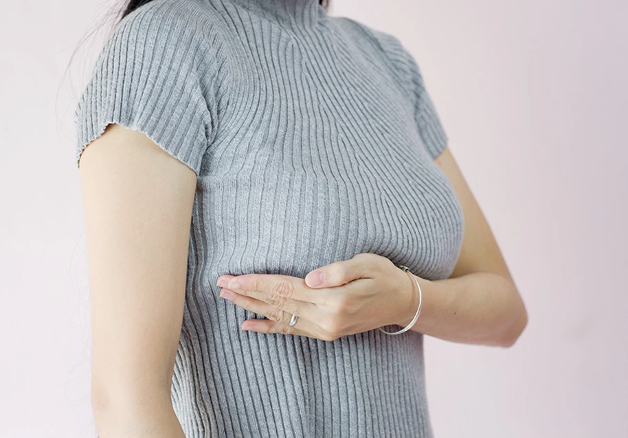 woman performing a self-exam on her breast