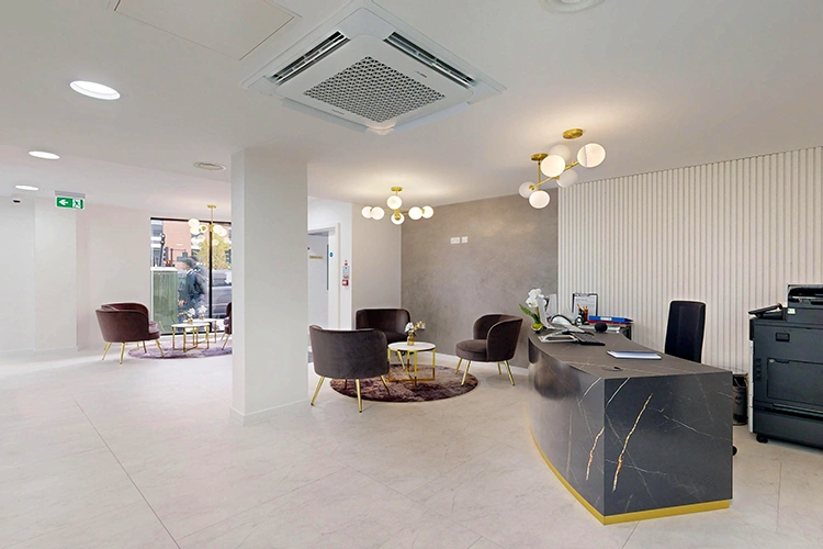 Spacious reception at London Private Hospital with curved marble desk, multiple seating areas and modern gold lighting.