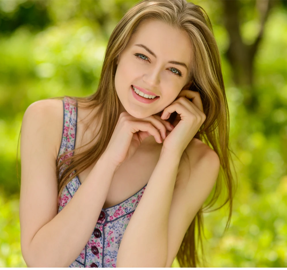 Smiling woman with a defined chin and jawline, representing chin liposuction results